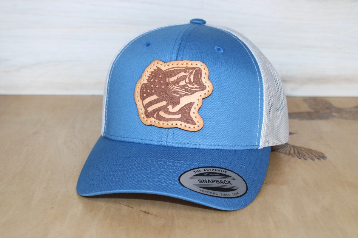 Blue and white trucker cap with leather patch displaying a fish