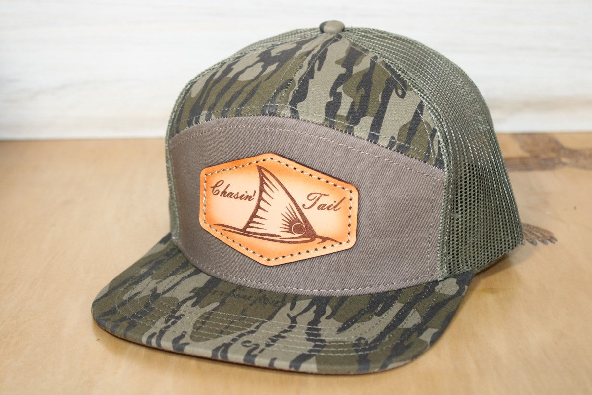 Camouflage trucker hat with a leather patch chaisin' tail