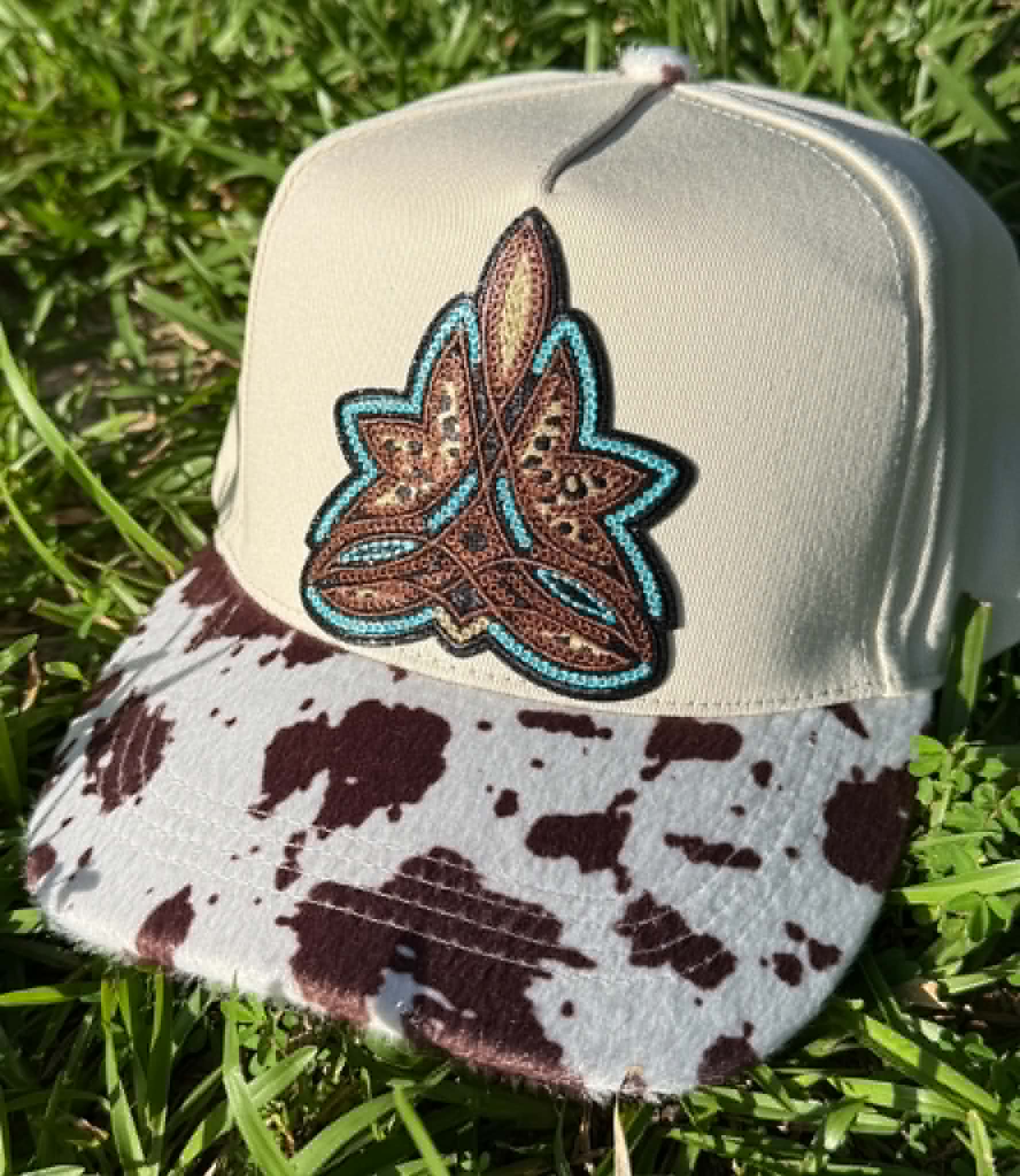 Cap with decorative emblem on a grass background