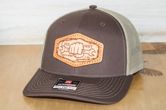 Brown and beige cap with leather patch on a wooden surface