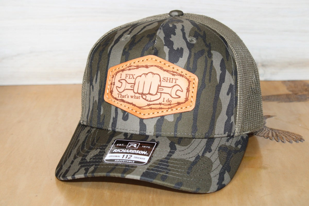 Camouflage trucker hat with leather patch on a wooden surface