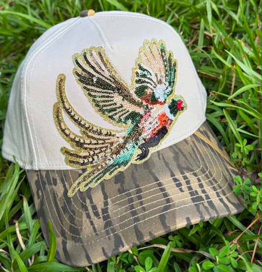 Cap with a pheasant design on a grass background