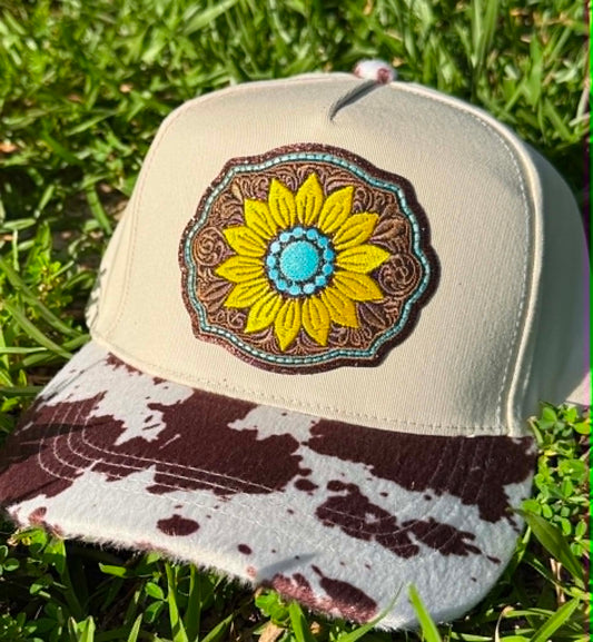 Beige cap with a sunflower design on a grass background