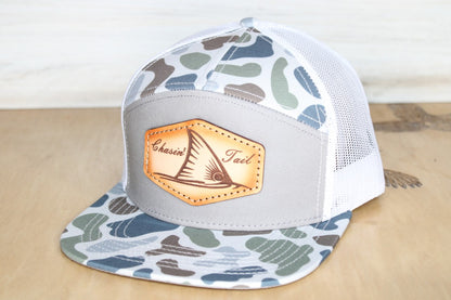 Camouflage trucker hat with a leather patch chaisin' tail