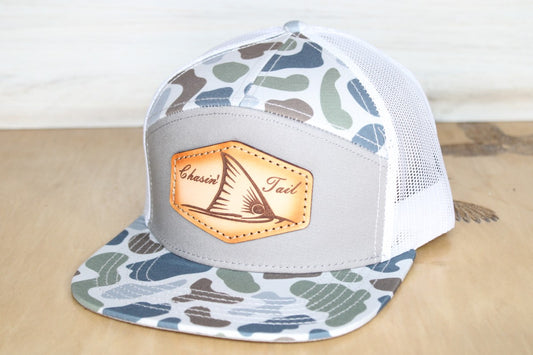 Camouflage trucker hat with a leather patch chaisin' tail